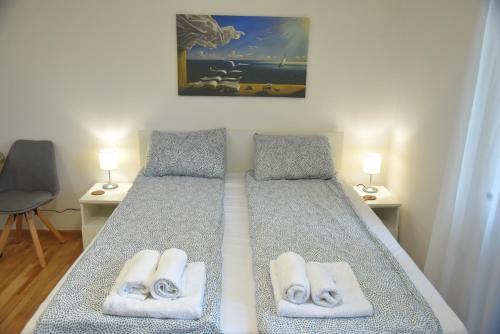 a bedroom with a bed with towels on it at Dekart Apartment in Niš