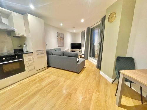 a kitchen and living room with a couch and a table at Chic Leeds City Apartment, Free Parking, Balcony in Leeds