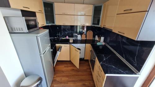 a small kitchen with a microwave and a refrigerator at Magic Sea View in Tsarevo