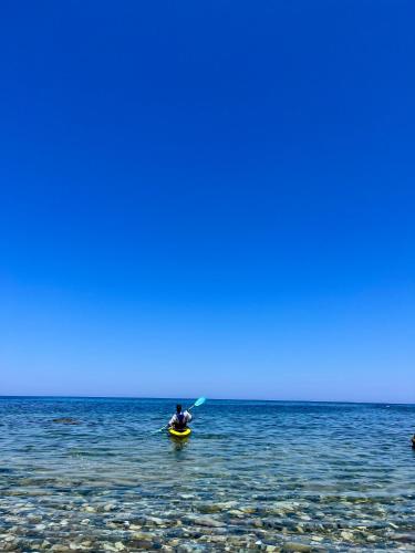 a person in a kayak in the ocean at Nautica Hotel Apartments in Stavromenos