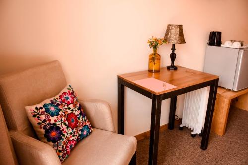 a room with a chair and a table with a pillow at Cooper Hotel Boutique in Cusco