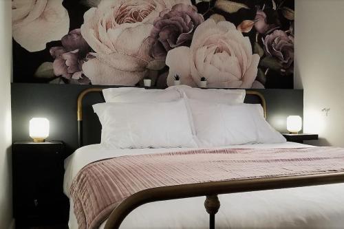a bedroom with a bed with a flower picture on the wall at L'Elegant - Cosy, Design et Charme en HyperCentre in Dijon