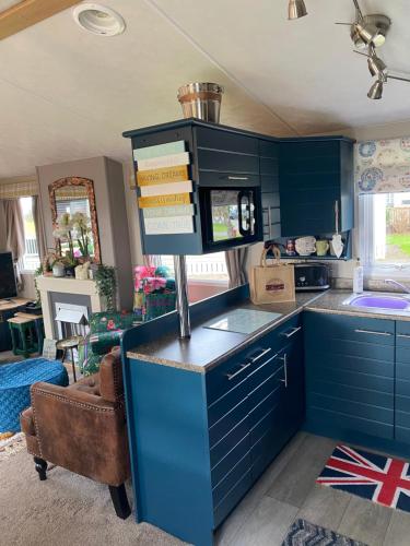 a blue kitchen with a counter with books on it at Serendipity in Sutton on the Forest