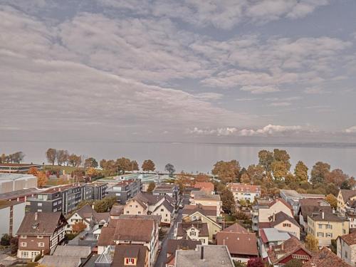 a city with houses and a body of water at Budgetapartment Seebühne von Swisspartments in Arbon