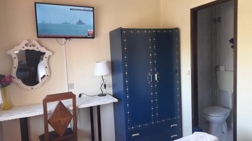 a room with a blue cabinet and a television on a wall at Residencia Maria Jose in Fátima