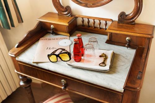 a table with a tray of glasses and a plate at Weisses Rössl in Caldaro