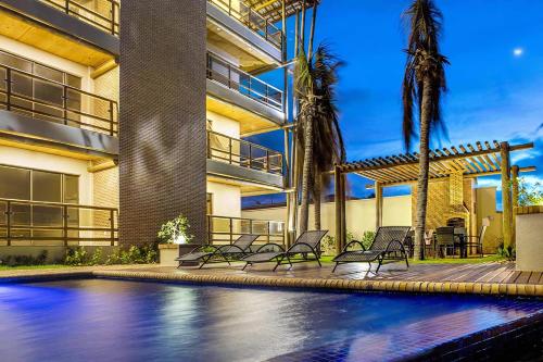 una casa con piscina y palmeras en Varandas Do Mar Modern Deluxe Apartment Beach Front Cumbuco, en Cumbuco