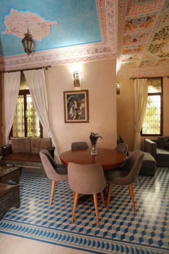 a living room with a wooden table and chairs at Equi Palace & SPA Near Aeroport in Berrechid