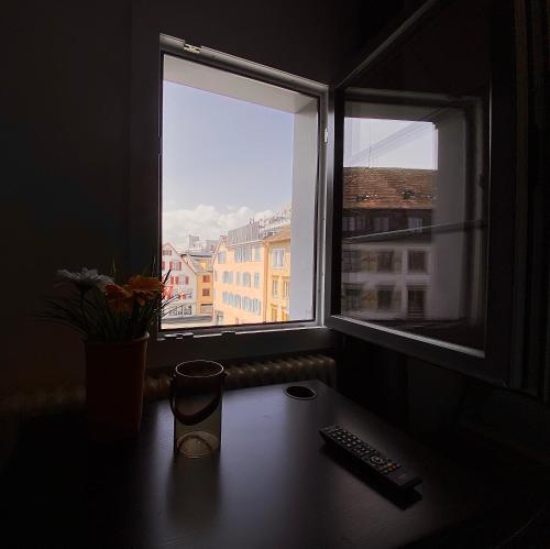 escritorio con mando a distancia y ventana en Budgetapartment Pfänder von Swisspartments en Arbon