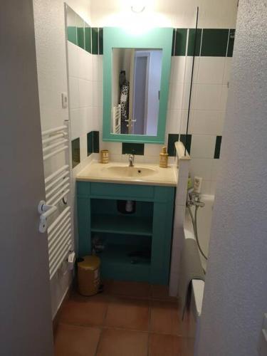 une salle de bain avec un lavabo bleu et un miroir dans l'établissement Appartement 3 pièces, 6 perso avec piscine chauffée en saison domaine du golf de Pinsolle, à Soustons