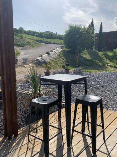 two tables and two stools sitting on a porch at Le 7 in Vieille-Toulouse