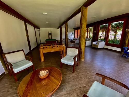 a living room with a table and a pool table at Maresias, Chalé H29 em condomínio de frente a Entrada 18 da praia e dentro da Mata Atlântica in São Sebastião