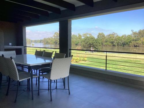 a dining room with a table and chairs and a large window at Harpy Haven in Parys