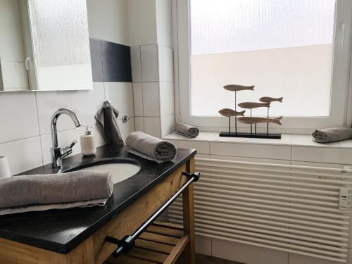 a bathroom with a sink and two stools in a window at Ferienwohnung Meersalz in Wittdün