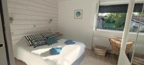 Un dormitorio con una cama con toallas azules. en Gîte à la campagne en Saint-Brice-sur-Vienne
