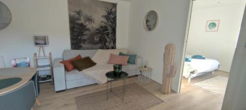 sala de estar con sofá y cama en Gîte à la campagne en Saint-Brice-sur-Vienne