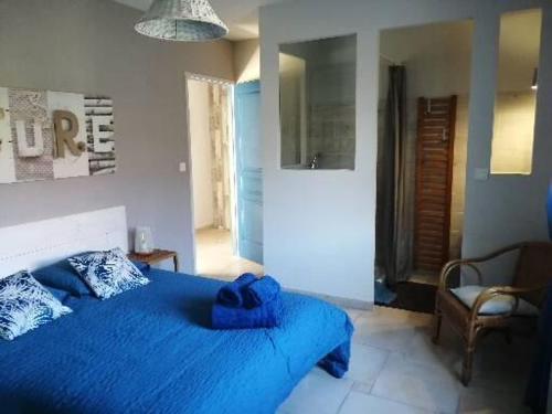 a bedroom with a blue bed and a chair at Appartement de vacances à la campagne in Saint-Jean-Pla-de-Corts