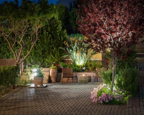 a garden at night with flowers and plants at Olea Suites in Gouves