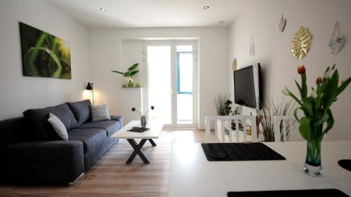 Una sala de estar con un sofá y un televisor. en Lovely Hohen Neuendorf, en Hohen Neuendorf