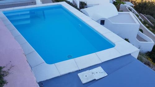 an overhead view of a swimming pool with blue water at Apollon Village Hotel in Anafi