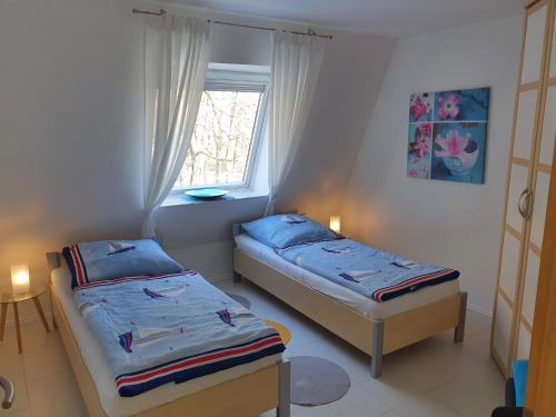 two beds in a small room with a window at Villa Seeschwalbe Plau in Plau am See