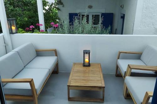 a patio with two couches and a table with a candle at Niso in Livadion
