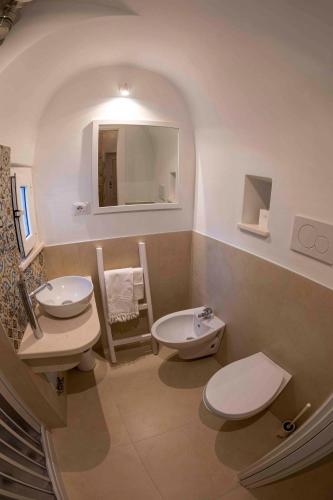 a bathroom with two sinks and a toilet and a mirror at Il Campanile in Cisternino