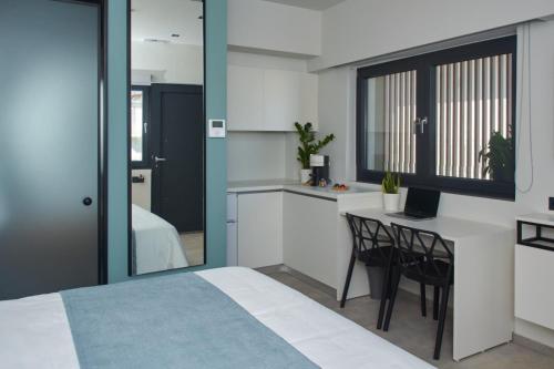 a bedroom with a bed and a desk with a computer at 7Rizes Luxury Living in Heraklio Town
