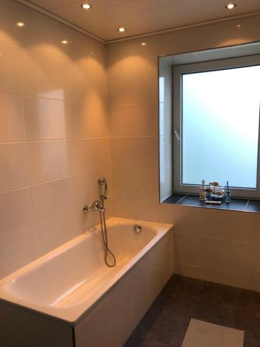 a bath tub in a bathroom with a window at Ferienhaus Cassel in Kassel