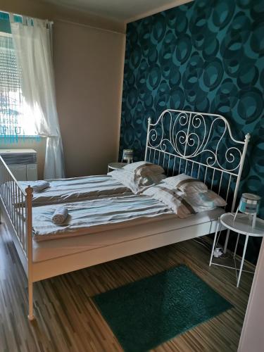 sypialnia z łóżkiem i zieloną ścianą w obiekcie Zso-Zé Apartman w mieście Tiszafüred