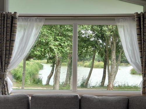 a living room window with a view of a river at Lakeside Caravan White Acres Holiday Park Newquay Sleeps 6 in Saint Enoder