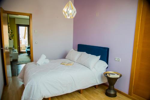 a bedroom with a white bed with a blue headboard at Mirador Islas de Arousa in Ribeira