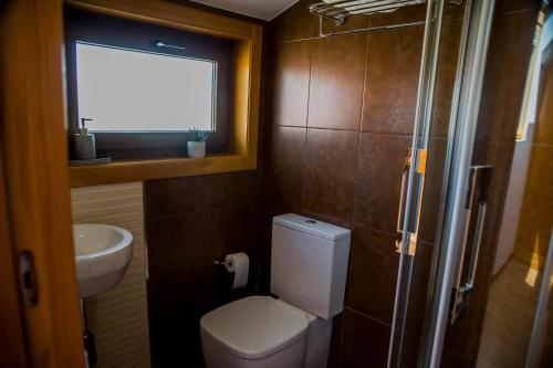 a bathroom with a toilet and a sink and a window at Mirador Islas de Arousa in Ribeira