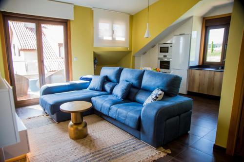 a living room with a blue couch and a table at Mirador Islas de Arousa in Ribeira