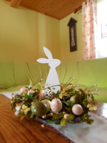 a table with an arrangement of eggs and a bunny on it at Domki i Apartamenty Rogate Anioły in Wetlina