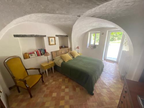 - une chambre avec un lit vert et une chaise dans l'établissement La Genevraie, à Gap