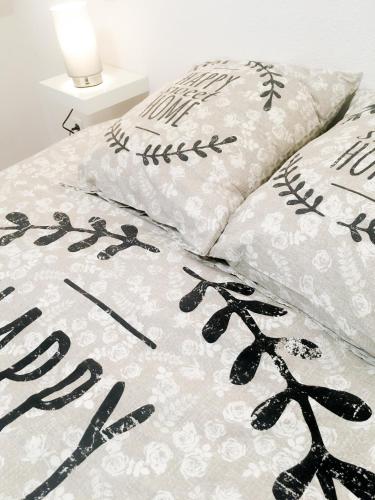 - un lit avec des draps et des oreillers en noir et blanc dans l'établissement Le gite 7 - Les Châteaux d'Ottrott, à Sélestat