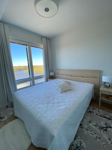 a bedroom with a large white bed with a window at River 29, Baritoni in Pori