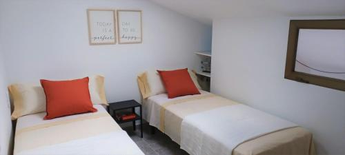 Habitación con 2 camas y TV. en Agradable casa con terraza en S'Agaró, en Sant Feliu de Guíxols