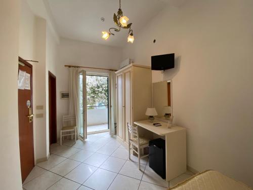 a room with a desk and a room with a window at Hotel La Perla in Praiano
