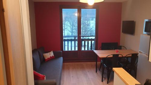 ein Wohnzimmer mit einem Sofa, einem Tisch und einem Fenster in der Unterkunft SCI jsm in Gresse-en-Vercors