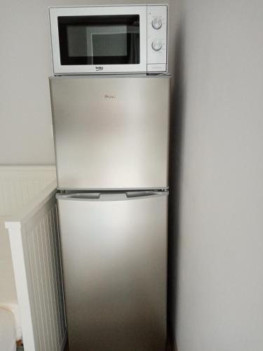 un micro-ondes posé sur un réfrigérateur dans l'établissement Au Coeur du Luberon, à Cavaillon