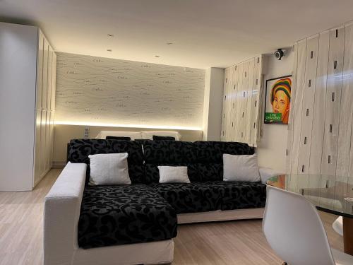 a living room with a black couch and a glass table at Black and White Suitte "Marques" in Noja