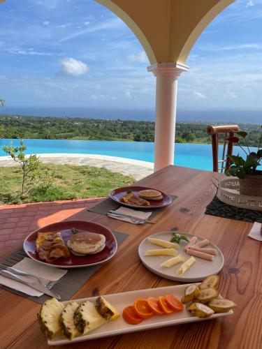 a wooden table with plates of food on top of it at El Castillo Tropical in Cabrera