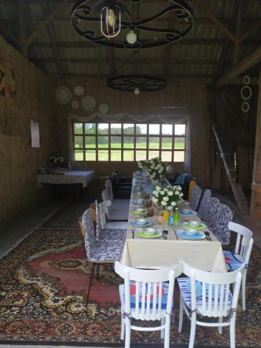 Długa jadalnia z długim stołem i krzesłami w obiekcie Dom w malowniczej wsi z imprezową stodołą Hot Tub jacuzzi w mieście Zakrzewo Zalesie
