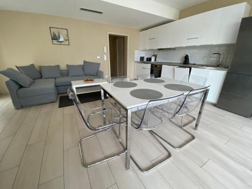 cocina y sala de estar con mesa y sillas. en Balatoni Élmény - csopaki apartmanlakások 20 méterre a Balatontól, en Csopak