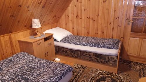 a room with two beds and a lamp on a table at Zielona Sielanka in Orzyny