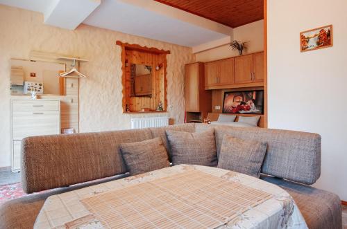 a living room with a couch and a kitchen at Villa Alexandr in Alsópáhok