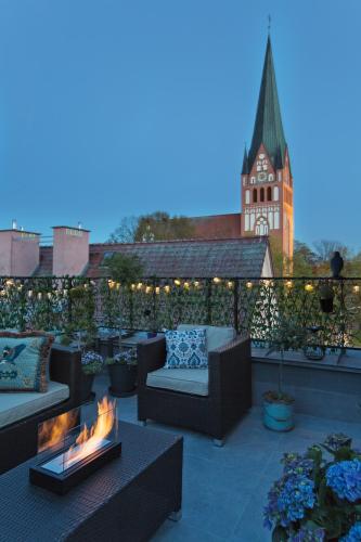 a patio with couches and a fire pit on a roof at Loft Barnim w wieży strażackiej, 2-poziomowy, 100m2, taras na dachu in Szczecinek