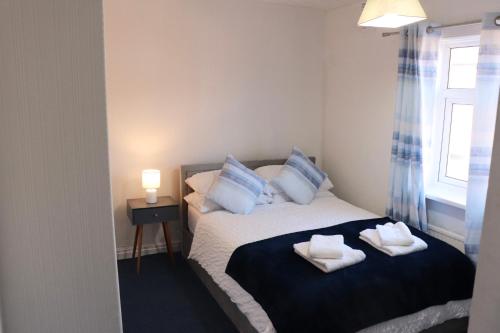 a bedroom with a bed with towels on it at Spacious & Comfortable 3 Bedroom House - FREE WiFi & FREE Parking in Killingbeck